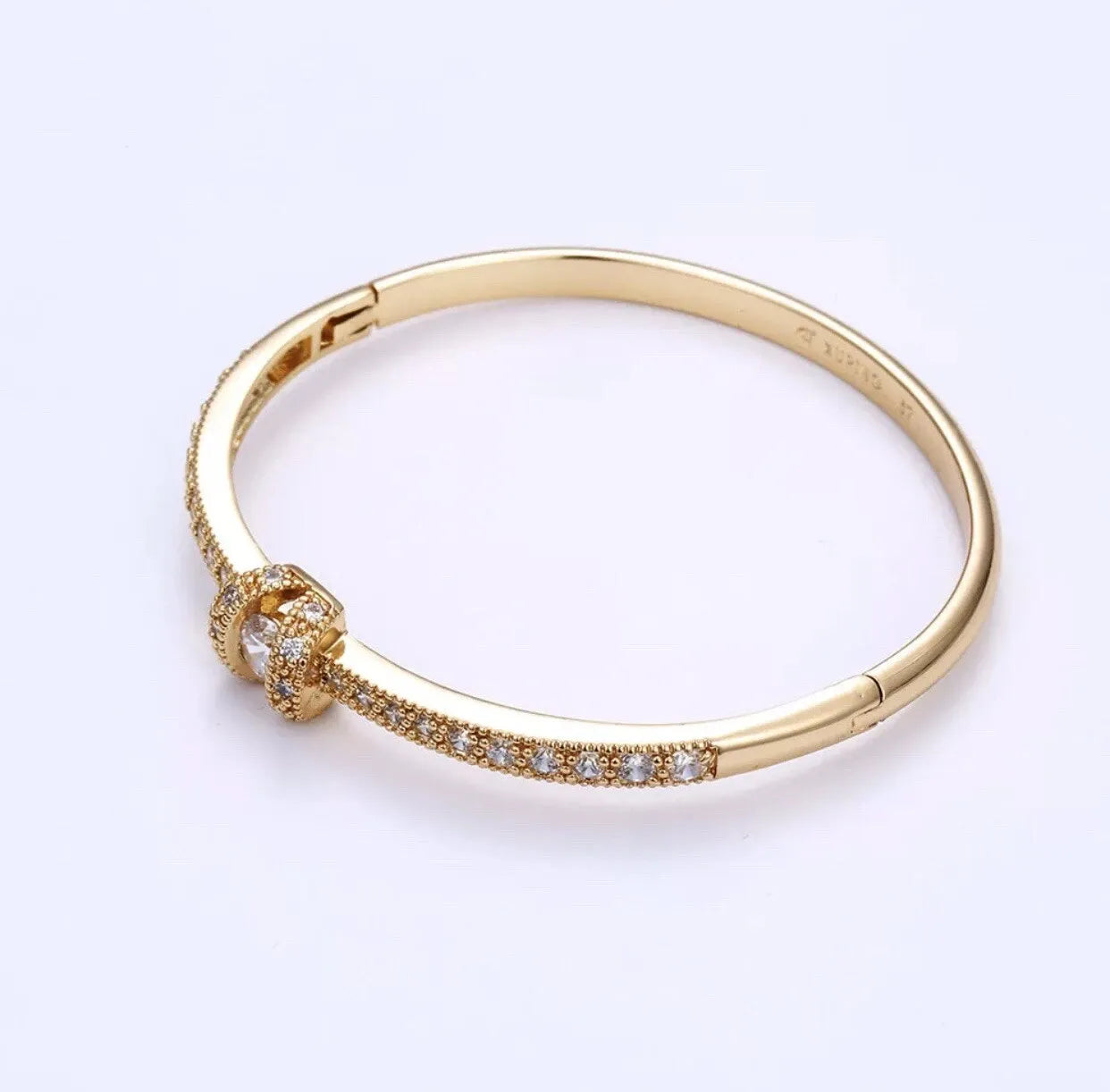 Gold bracelet with a clasp on a white background
