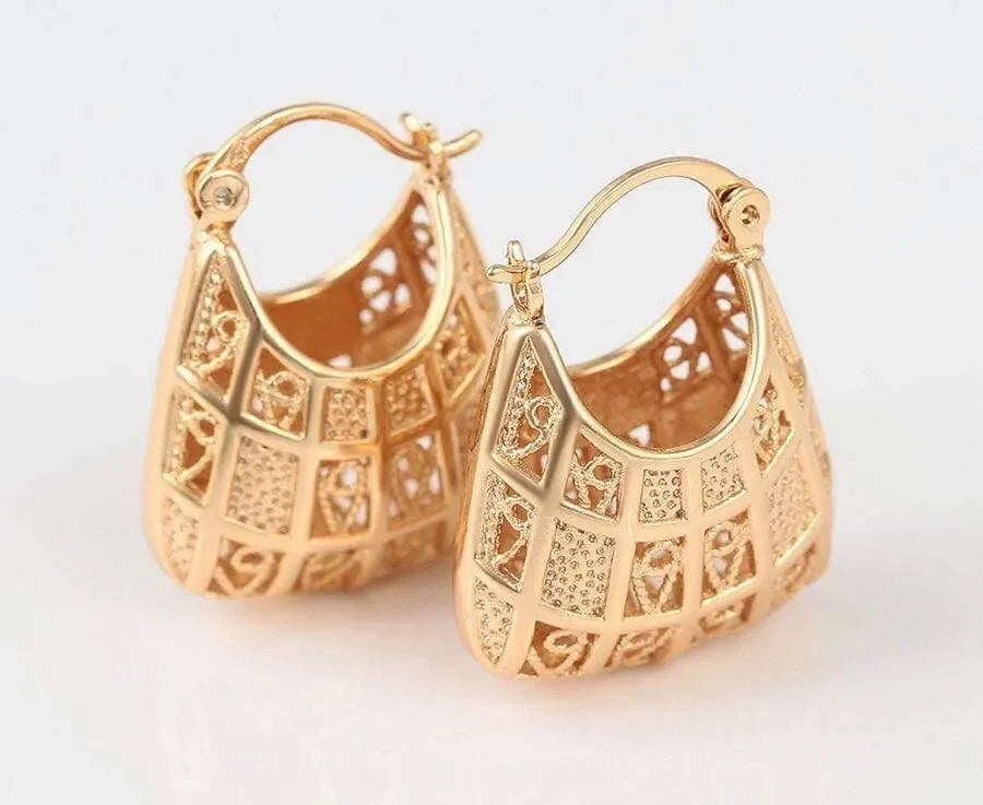 Gold hoop earrings with intricate designs on a white background