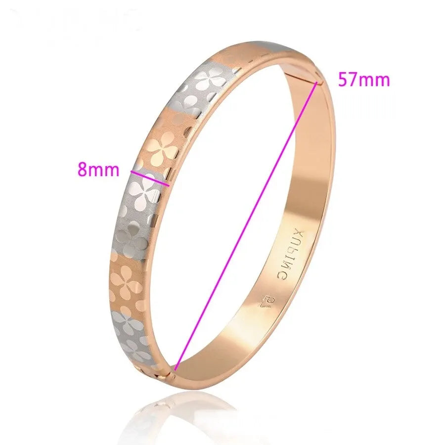 Gold and silver bangle with measurements on a white background