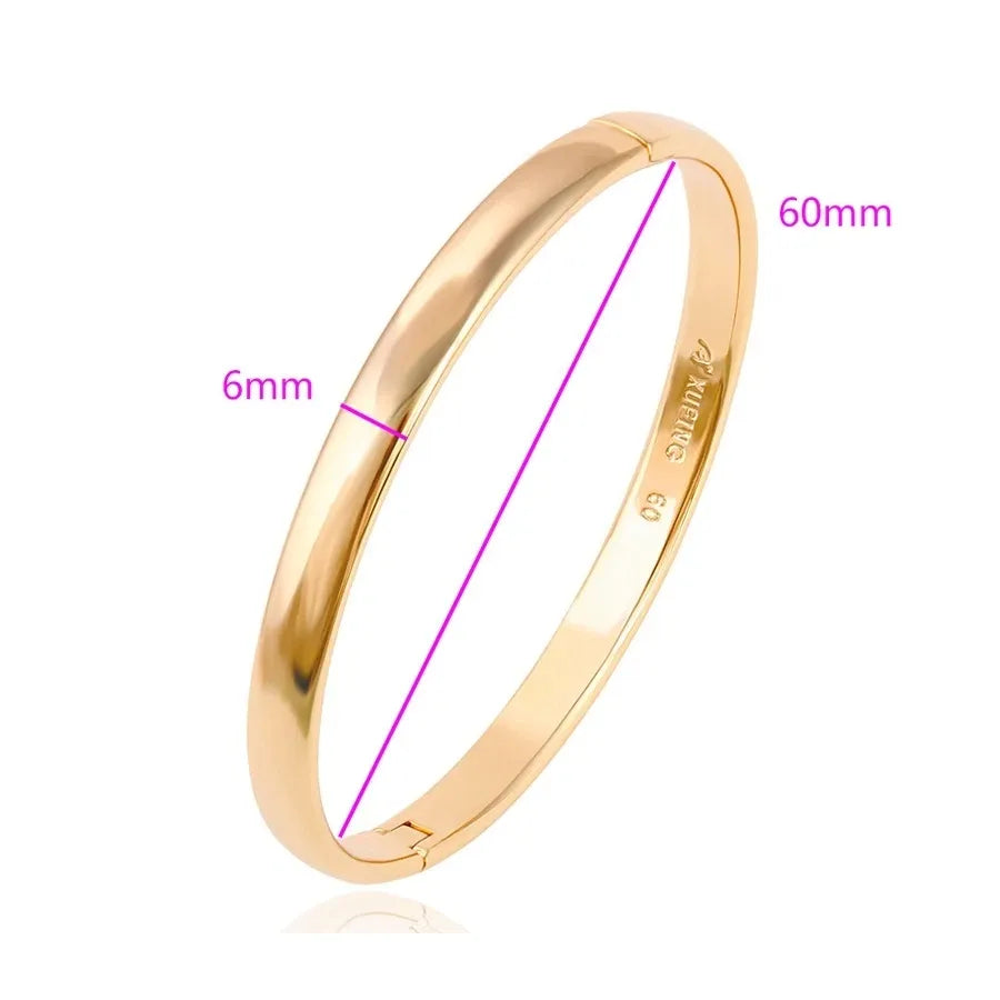 Gold bangle with measurements on a white background