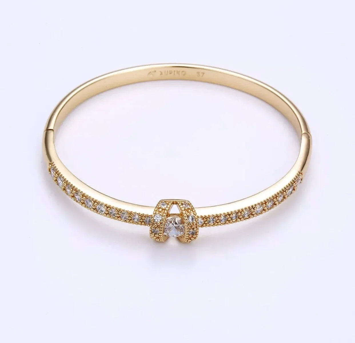 Gold bracelet with diamond accents on a white background