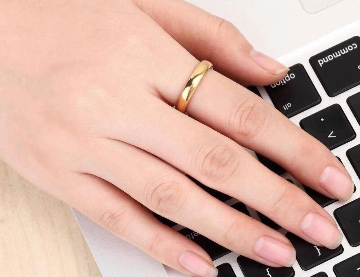 Hand wearing a gold ring 