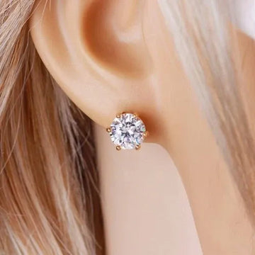 Close-up of an ear wearing a diamond stud earring with blonde hair.