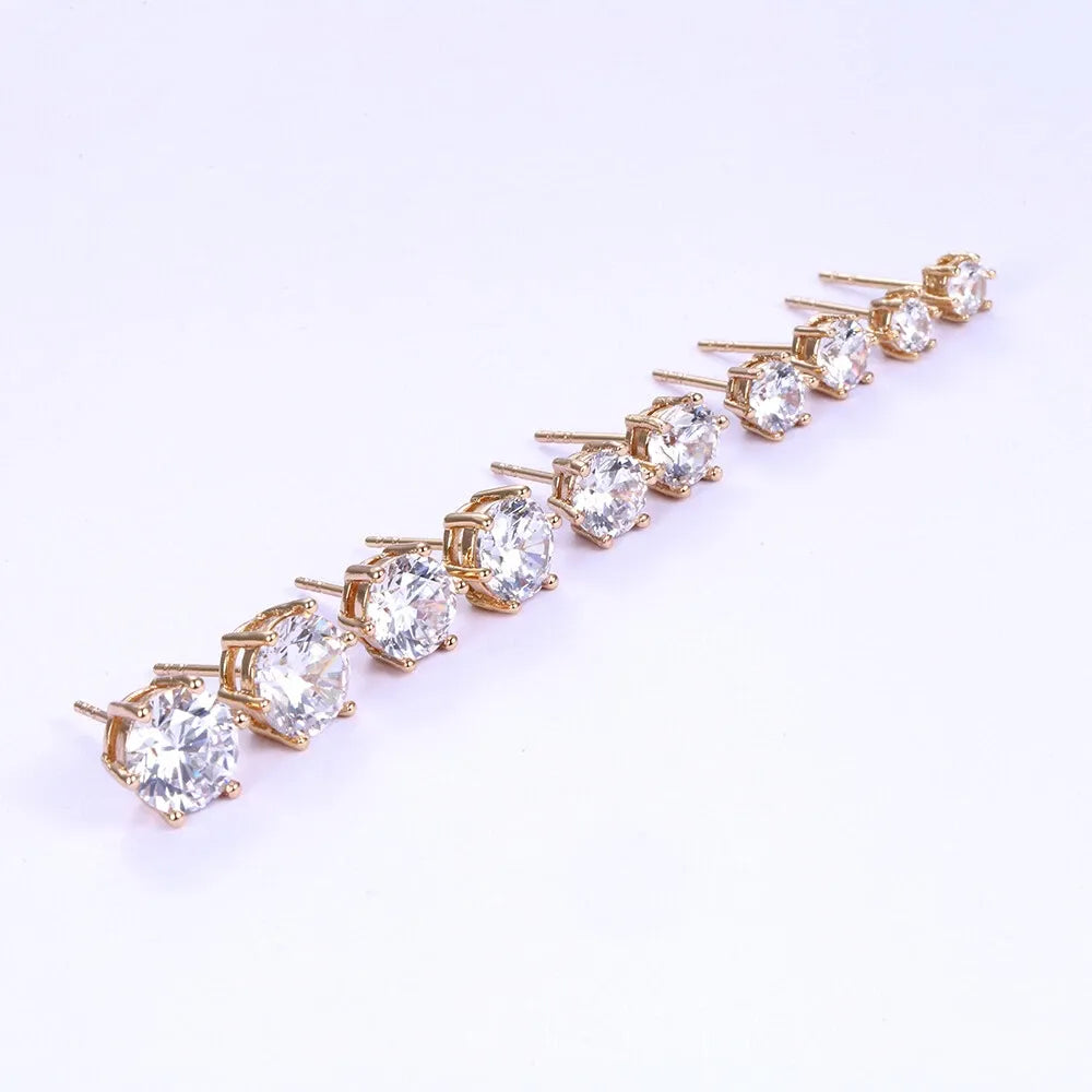 Gold earring with clear gemstones on a white background