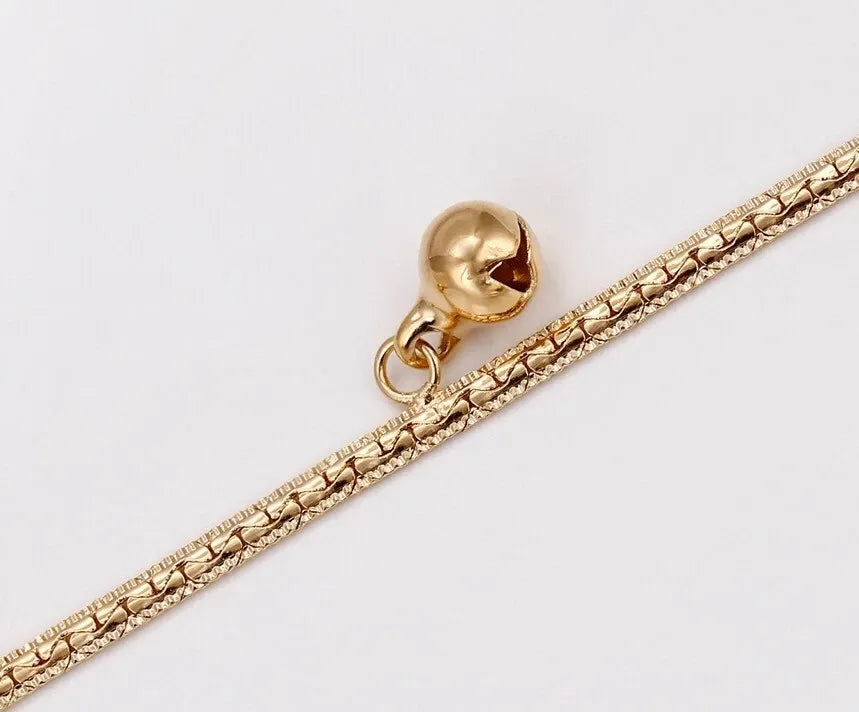 Gold chain with a spherical pendant on a light gray background