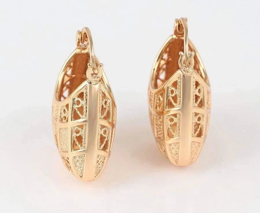 Pair of gold hoop earrings with intricate designs on a white background