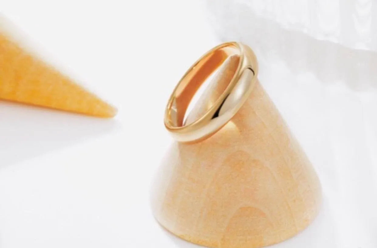 Gold ring with a unique design on a white background