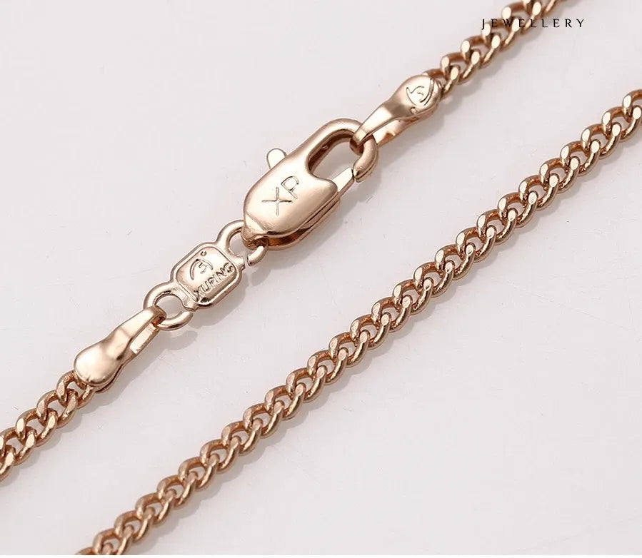 Rose gold chain necklace on a light gray background