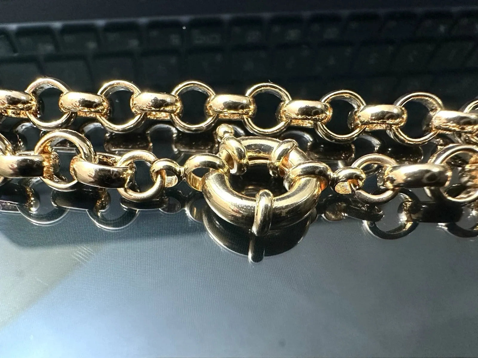 Gold chain on a reflective surface