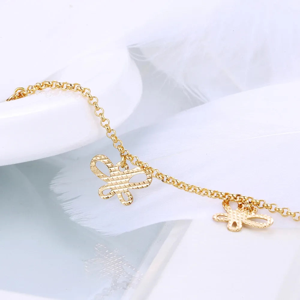 Gold bracelet with butterfly charms on a white background