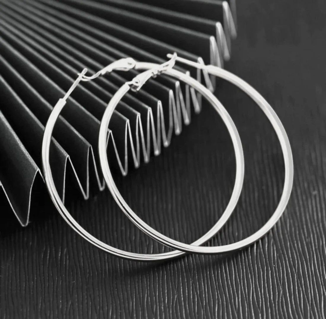 Gold hoop earrings on a textured surface