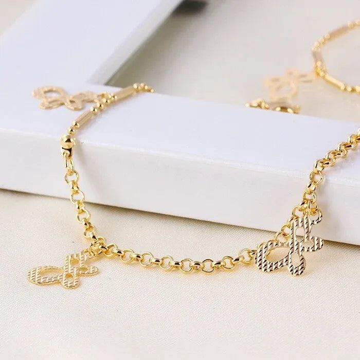 Gold bracelet with charms on a white surface