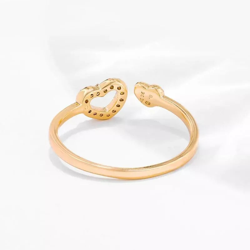 Gold open bangle with snake design on a white background