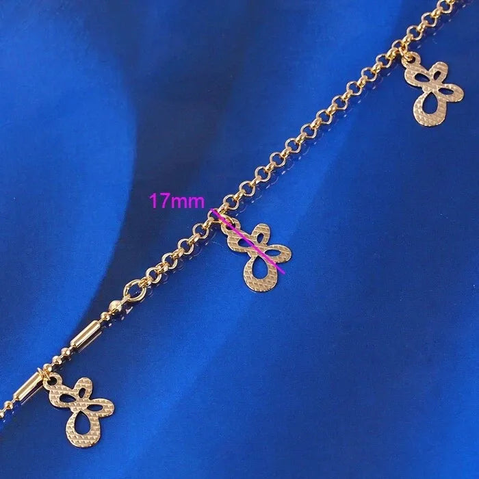 Gold anklet with butterfly charms on a blue background