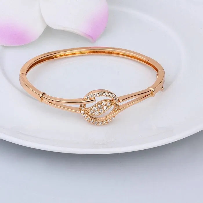 Rose gold bracelet with heart design on a white plate