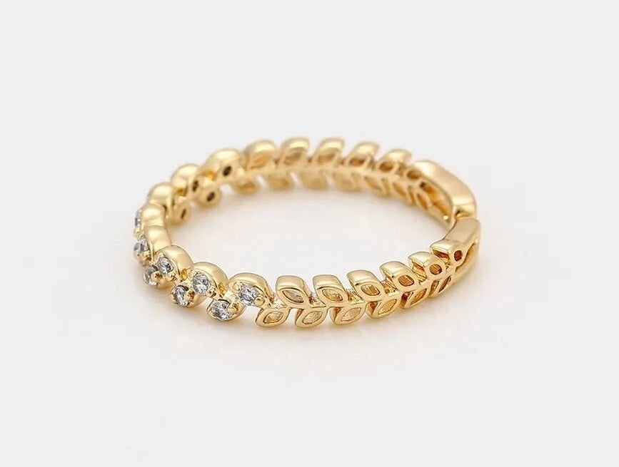 Gold ring with diamond accents on a light beige background