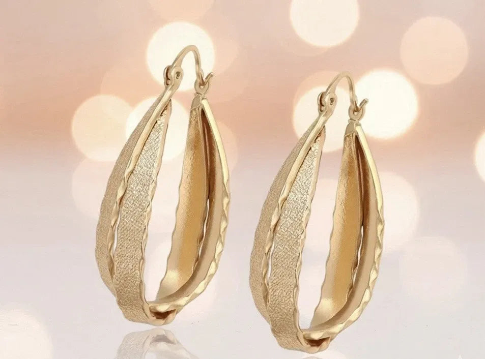 Gold hoop earrings on a blurred background