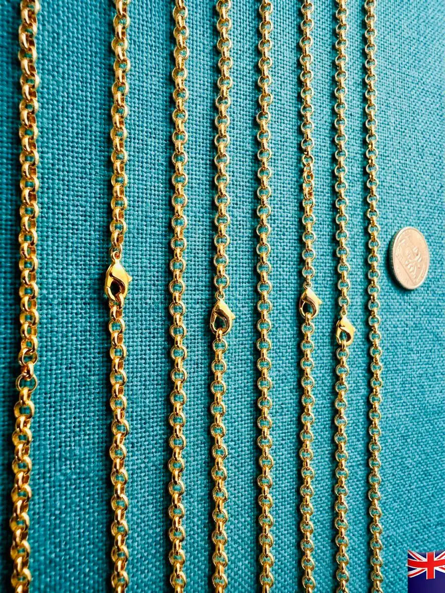 Gold chains of different lengths on a teal fabric background