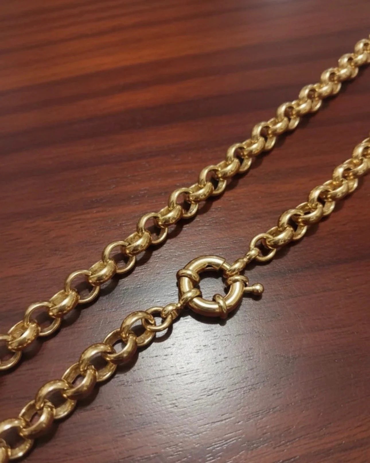Gold chain with a clasp on a wooden surface