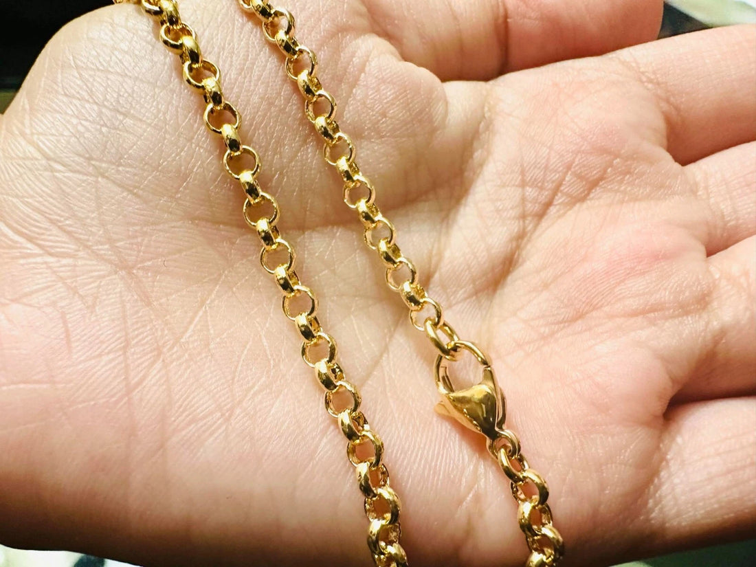 Gold chain bracelet on a reflective black surface