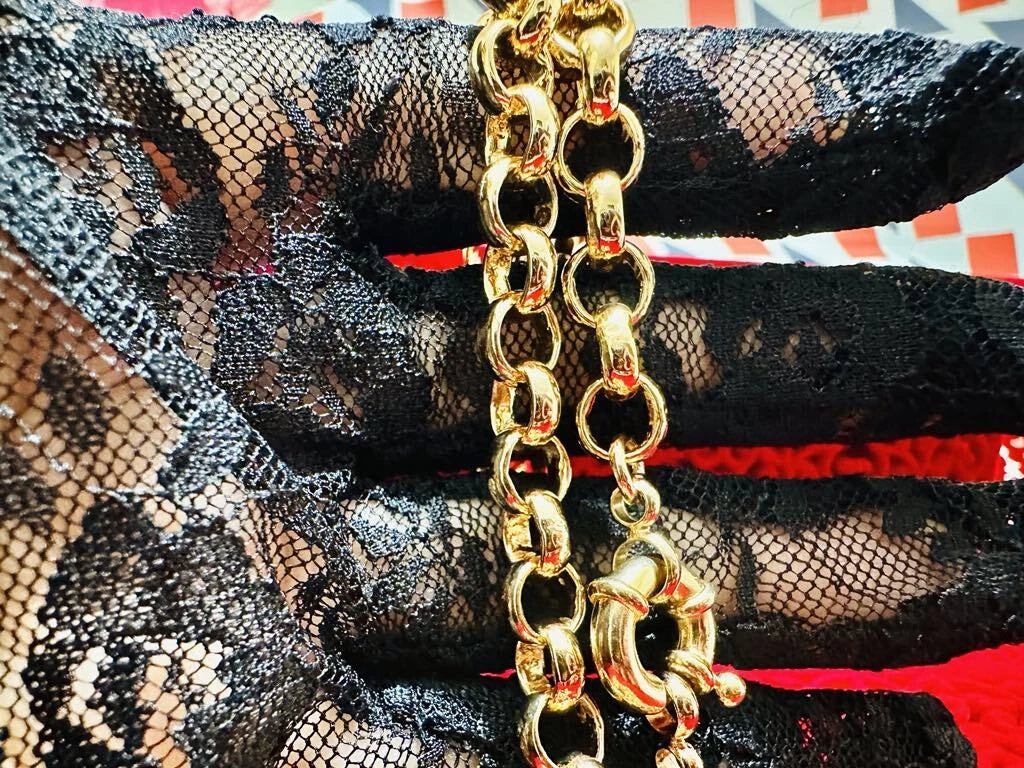 Gold chain necklace on black lace fabric