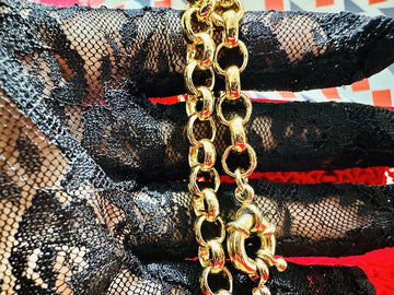 Gold chain necklace on black lace fabric