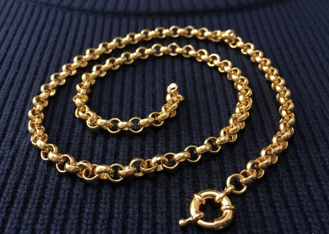 Gold chain necklace with a clasp on a dark blue textured background